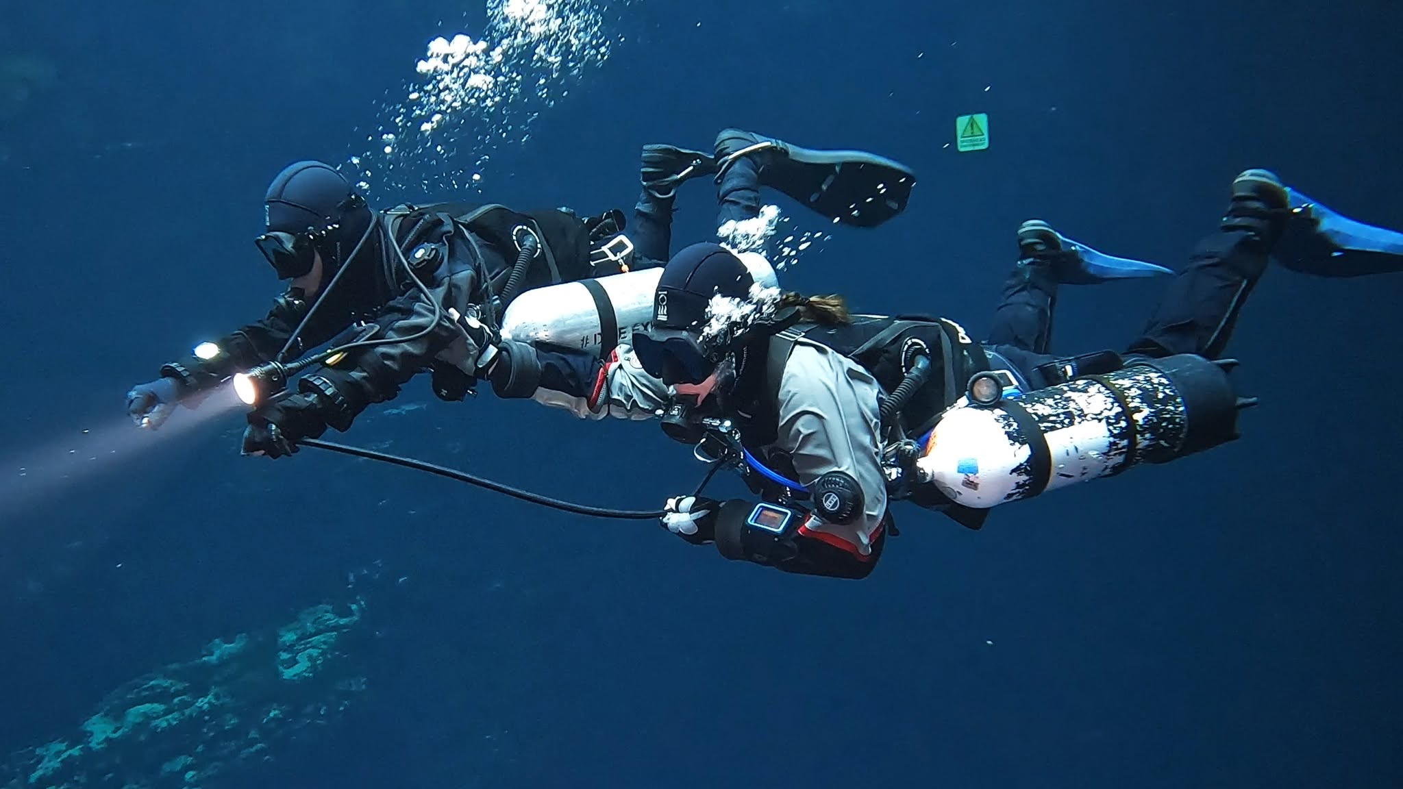 Two sidemount divers practising skills side by side